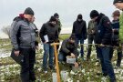 Gruppe Studierender testet mit einem Berater die Wasserinfiltration in den Boden.