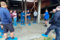 Gruppe Studierende mit Betriebsleiter vor einem Stall